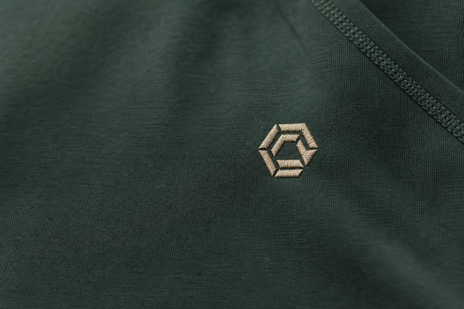 Embroidered geometric detail on green activewear fabric