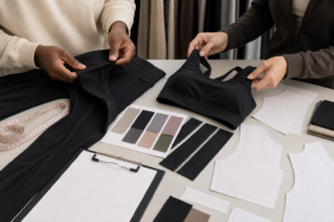 Product development team reviewing unbranded yoga apparel samples, pattern pieces, and fabric swatches